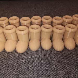 Peut inclure: Un ensemble de 14 petits contenants en forme de bottes de couleur beige. Les contenants sont faits d'un matériau lisse, semblable au plastique.