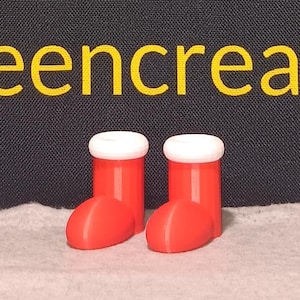 Könnte beinhalten: Zwei rote und weiße Weihnachtsstrumpfornamente mit weißem Fellbesatz.