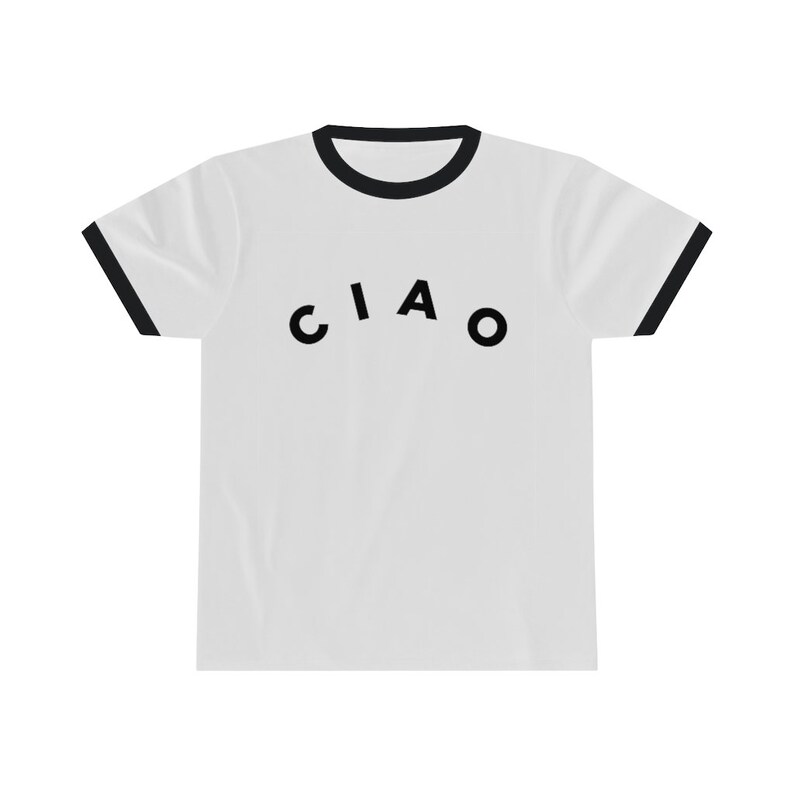 May include: White t-shirt with black trim on the collar and sleeves. The word "CIAO" is printed in black, arched across the front of the shirt. The shirt is made of a soft, comfortable material.