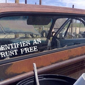 May include: A rusty, blue pickup truck with a sticker on the back window that reads "Identifies as Rust Free".