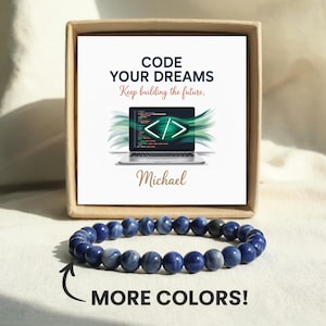 May include: A blue beaded bracelet with a card that reads "CODE YOUR DREAMS" and "Keep building the future." The card features a laptop with a coding interface. The name "Michael" is below the laptop. The words "MORE COLORS!" are at the bottom.