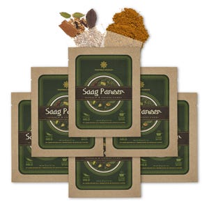 May include: A collection of Saag Paneer spinach and cheese curry packets with the text "Inspired Indian." The packets are brown with a green label and a picture of the curry. Spices such as cardamom, cinnamon, and curry powder are also visible.