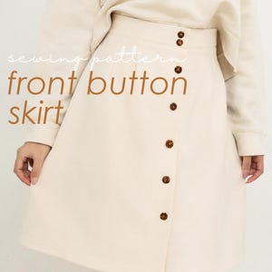 Peut inclure: Jupe crème à boutons sur le devant, de coupe trapèze. La jupe est ornée d'une série de boutons marron sur le devant et est associée à un pull crème assorti. Le texte "sewing pattern front button skirt" est visible.
