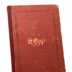 May include: A red book with a gold border and the word "KOБЗАР" printed in orange on the front cover.