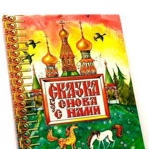 Pode incluir: Um livro infantil vintage com uma capa vermelha, amarela e verde. O livro apresenta uma ilustração colorida de uma igreja com uma cúpula dourada e um título que diz "СКАЗКА СНОБА С НАМИ".