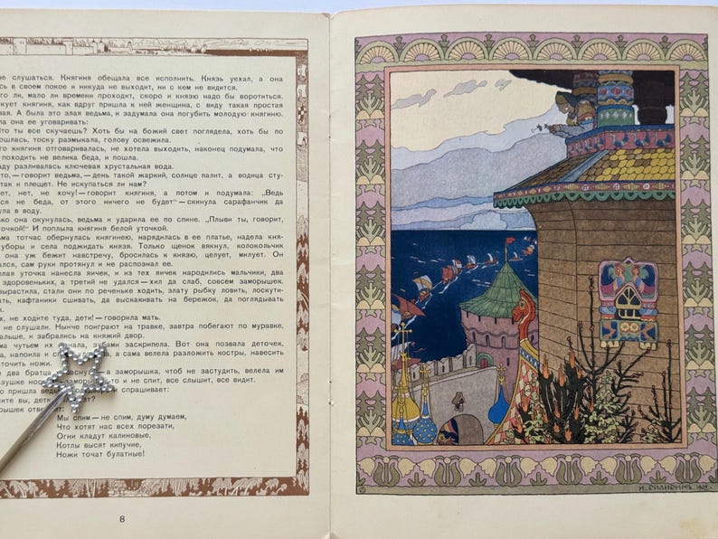 May include: An open book with a colorful illustration of a castle and water, framed by a decorative border. The page on the left contains text in a foreign language, while the right page features the artwork.