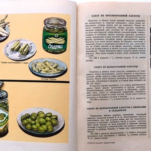 May include: A vintage Russian cookbook with images of various canned vegetables, including asparagus, green beans, and olives. The text on the page is in Russian and describes different salad recipes using these vegetables.