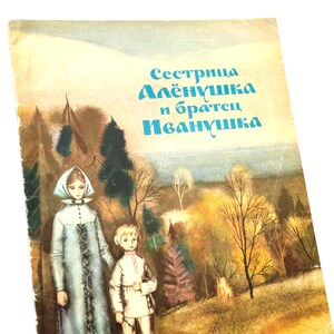 Pode incluir: Capa de livro vintage com uma ilustração de floresta e texto em russo. A capa mostra duas figuras em uma paisagem com árvores. O título está em azul. A capa tem uma aparência desgastada e envelhecida, sugerindo que é uma antiguidade ou um item de colecionador.