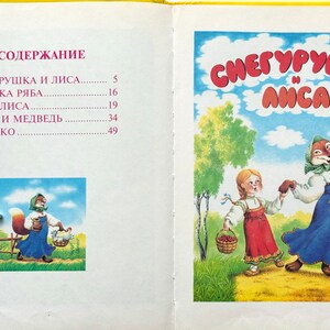 May include: A vintage children's book cover featuring an illustration of a girl in a red dress and a fox in a blue dress dancing in a forest. The title of the book is "СНЕГУРУШКА И ЛИСА" which translates to "Snow Maiden and the Fox".