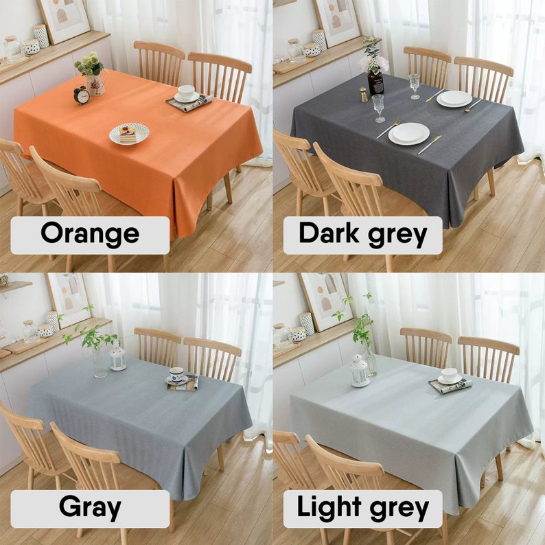 May include: Four tablecloths in different colors: orange, dark gray, gray, and light gray. Each tablecloth is laid on a wooden table with four chairs. The tablecloths are made of a textured fabric.