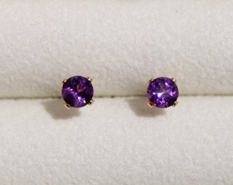 May include: A pair of amethyst stud earrings with gold settings.