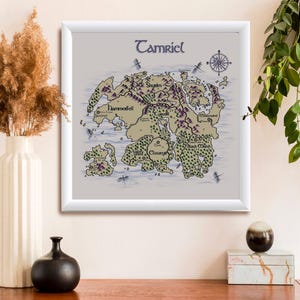 May include: A square framed wall art print featuring a detailed map of the continent of Tamriel. The map displays various regions including Skyrim, Hammerfell, and Cyrodiil with labeled locations, mountain ranges, and forests on a light background.