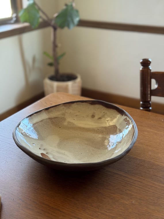 A large, organic-form stoneware bowl that doubles as a table centerpiece — the kind of piece that makes guests ask 'where did you get that?'