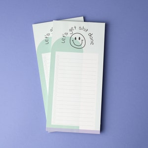 Peut inclure: Deux blocs-notes de to-do list bleu clair et vert avec un smiley et le texte "Let's get shit done".