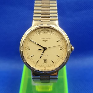 Vintage LONGINES Conquest Unisex quartz watch. Day/Date and Gold color style.