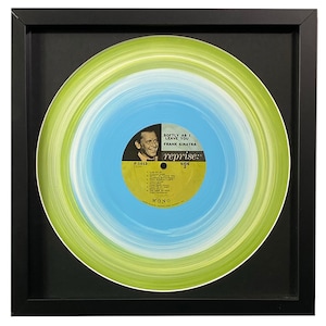 May include: A framed vinyl record with a blue and green swirl design. The record label is yellow and features a photo of Frank Sinatra and the text "Softly As I Leave You" and "Reprise" in black. The record number is F-1013 and the side is 2.