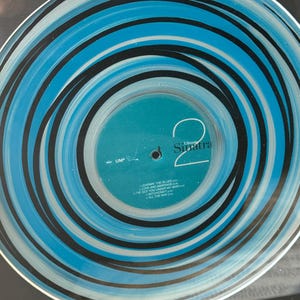 May include: A vinyl record with a blue, black, and white spiral design. The record label features the name "Sinatra" and song titles including "Learning the Blues" and "Love and Marriage."