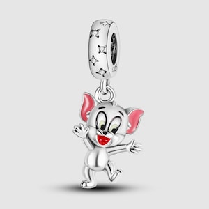 May include: Silver charm featuring a cartoon character of a gray mouse with pink ears, wearing a white shirt and red pants. The charm has a silver ring with a star design.