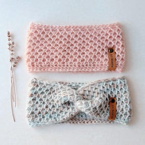May include: Two crocheted headbands, one in pink and one in blue and brown, with a brown leather tag that says "GO NORTH".