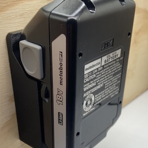 Peut inclure: Une batterie noire 18V Li-ion metabo HPT avec une étiquette argentée. La batterie est étiquetée "BSL 1815" et porte une étiquette d'avertissement avec le texte "CAUTION", "WARNING" et "AVERTISSEMENT".