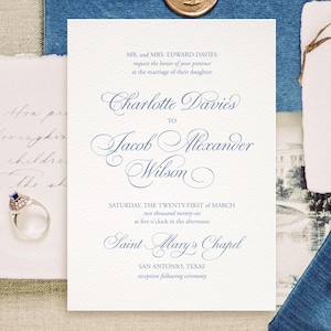 Puede incluir: Un conjunto de invitaciones de boda con un sobre azul marino, un sello de cera dorado y una invitación formal con una escritura elegante. El texto de la invitación dice "Charlotte Davies a Jacob Alexander Wilson".