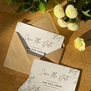 May include: Save the Date card with a leafy green design and the text "Save the Date" in a cursive font. The card is for the marriage of Jon and Amber on September 24th, 2022.