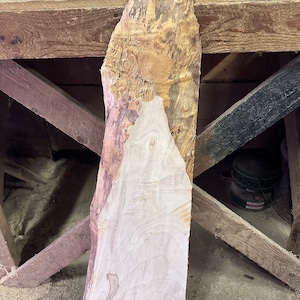 Pode incluir: Uma grande peça de madeira com uma cor castanho claro natural e um padrão de grão único. A madeira tem uma textura áspera e não acabada e é provavelmente adequada para projetos de carpintaria.