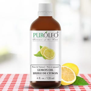 May include: A brown bottle of lemon oil with a white label featuring a lemon slice illustration and the text "PURÓLEO Science of the Raw". The bottle contains 120 ml of oil. A whole lemon and a lemon half are next to the bottle.