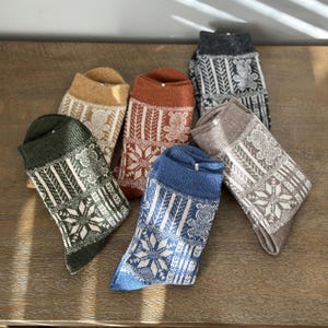 May include: Six pairs of colorful socks with a snowflake and bear pattern. The socks are made of a soft, warm material and are perfect for the winter.