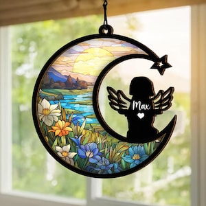 May include: A stained glass style moon with a sunset scene and flowers. A black silhouette of a dog with angel wings is in the moon. The dog's name "Max" is written on the image.
