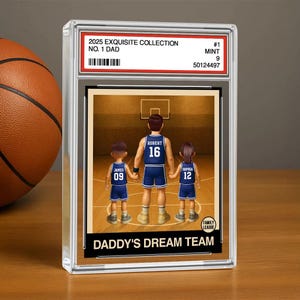 May include: A basketball card featuring a cartoon illustration of a family of four playing basketball. The card is framed in a clear plastic case and has the text "2025 Exquisite Collection No. 1 Dad #1 Mint 9 50124497" printed on the top. The card also has the text "Daddy's Dream Team" printed on the bottom.