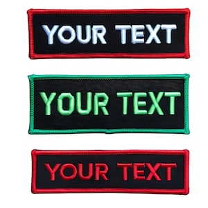 May include: Three black rectangular patches with white, green, and red embroidered text that reads "YOUR TEXT". The patches have red, green, and red stitching around the edges.