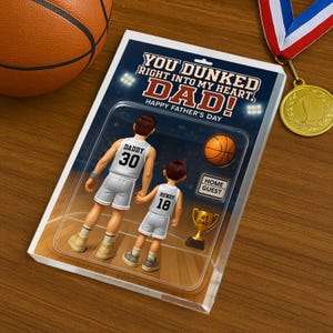 May include: A Father's Day card with a basketball theme. The card features a cartoon illustration of a father and son playing basketball. The text on the card reads "You dunked right into my heart, Dad! Happy Father's Day."