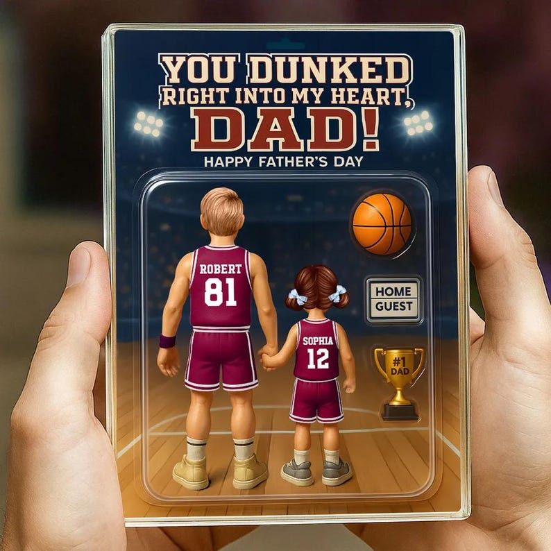May include: A personalized Father's Day card featuring a cartoon illustration of a basketball player with the text "YOU DUNKED RIGHT INTO MY HEART, DAD! HAPPY FATHER'S DAY". The card also includes a basketball, a trophy, and a sign that says "HOME GUEST".