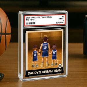 May include: A basketball trading card featuring a cartoon illustration of a father and two children playing basketball. The card is titled "Daddy's Dream Team" and includes the text "2025 Exquisite Collection, No. 1 Dad, #1 Mint 9, 50124497".
