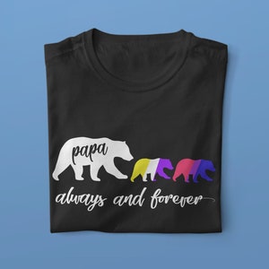 Op de afbeelding: Zwart T-shirt met een wit silhouet van een berenfamilie. De vaderbeer zegt "papa" en de jongen zijn gekleurd in geel, paars en blauw. De tekst "altijd en voor altijd" staat onder de beren.