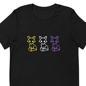 Könnte beinhalten: Schwarzes T-Shirt mit drei umrandeten Füchsen in Gelb, Weiß und Lila. Die Füchse sitzen und schauen nach vorne.