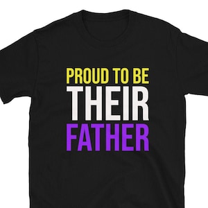 May include: Black t-shirt with the text "Proud to be their father" in yellow, white, and purple.