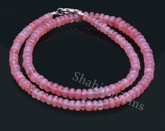 May include: A double strand necklace made of pink opal beads. The necklace is approximately 18 inches long and has a silver clasp.