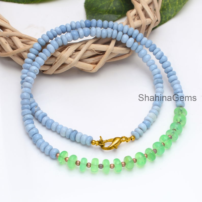 May include: A double-strand necklace with light blue and green beads. The necklace has a gold clasp.