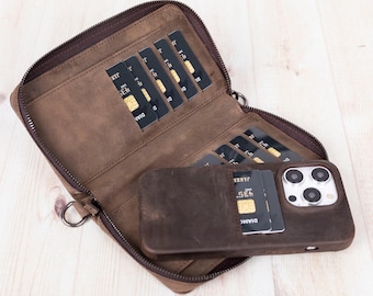 May include: A brown leather wallet with a wrap-around zipper, featuring multiple interior card slots filled with black credit cards. A matching brown leather phone case is attached to the interior, holding a smartphone and additional cards.