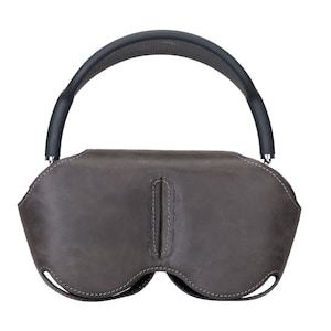 K&ouml;nnte beinhalten: Eine braune Ledertasche mit einem schwarzen verstellbaren Riemen f&uuml;r Kopfh&ouml;rer.