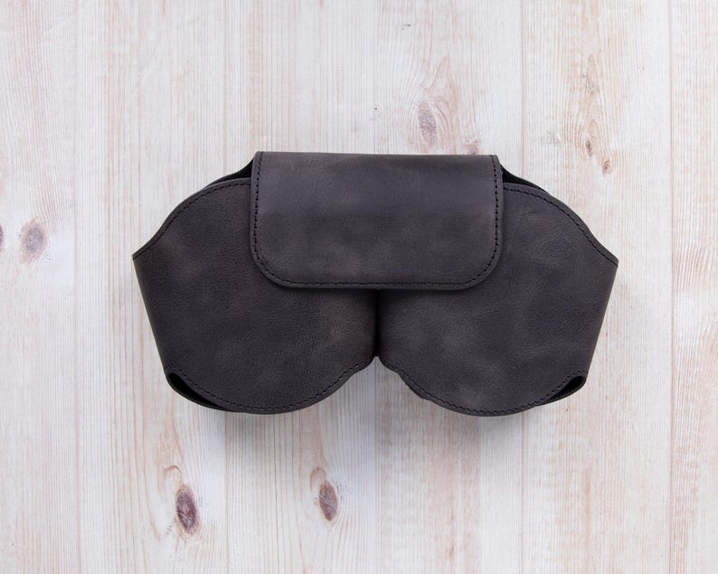 K&ouml;nnte beinhalten: Eine dunkelbraune Ledertasche mit zwei F&auml;chern zum Aufbewahren von Brillen oder anderen kleinen Gegenst&auml;nden.
