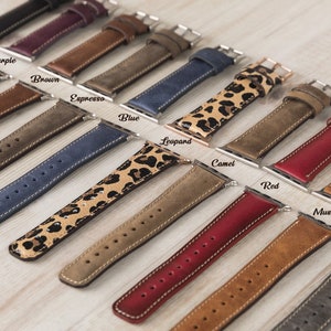 May include: A variety of leather watch bands in different colors and patterns, including black, purple, brown, espresso, blue, leopard, camel, red, mustard, gray, and rust.