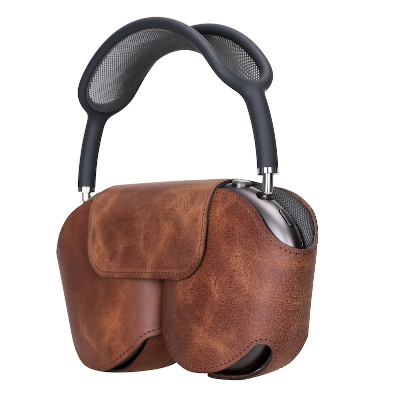 K&ouml;nnte beinhalten: Eine braune Ledertasche mit einem schwarzen Netzgriff f&uuml;r Kopfh&ouml;rer.