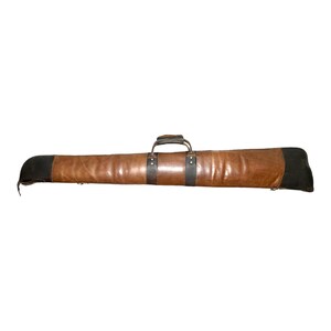 May include: A brown leather gun case with a black leather handle and end caps.