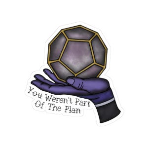 May include: A sticker showing a purple hand cradling a geometric, multi-faceted object with gold edging. The text "You Weren't Part Of The Plan" is printed on the sticker in a handwritten style.