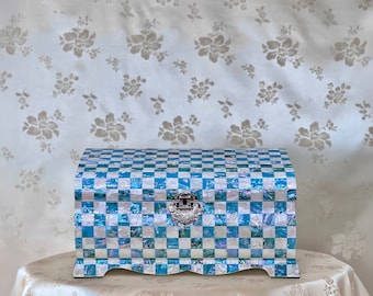 May include: A blue and white checkered jewelry box with a silver latch. The box is made of mother of pearl and has a scalloped edge.