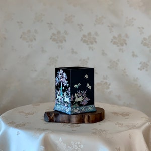 Peut inclure: Une boîte en bois noire avec un motif décoratif d'un arbre et d'un cerf en nacre. La boîte est sur une base en bois.