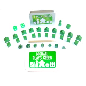 May include: A green game piece set with a green tin box that says "I Play Green" and a card that says "Michael Plays Green". The set includes a green player piece, a green pawn, a green die, and a green token.